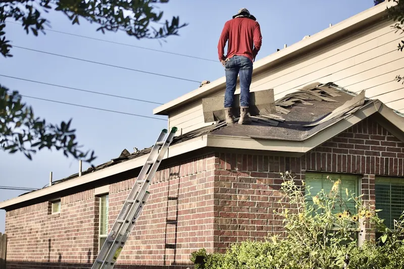 Professional roofer working on a residential roof in Friedens